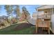 View of a backyard deck with stairs, surrounded by trees and grass at 739 Marlay Sw Ln, Powder Springs, GA 30127