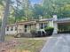 Ranch home with carport, situated on a wooded lot at 7508 Asbury Manor Dr, Lithonia, GA 30058