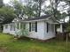 White house with black shutters and a brick foundation at 5015 Suwanee Dam Rd, Suwanee, GA 30024