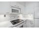 White kitchen with microwave, oven, and cooktop at 2870 Pharr Court South Nw # 607, Atlanta, GA 30305