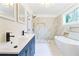 Modern bathroom with marble tile, soaking tub, and double vanity at 1875 Langston Sw Ave, Atlanta, GA 30310