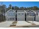 Three-unit townhome building, gray siding, two-car garages, and landscaping at 5142 Longview Run, Decatur, GA 30035