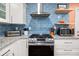 Modern kitchen with blue tile backsplash, granite countertops and gas range at 2769 Glenvalley Dr, Decatur, GA 30032