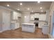 Modern kitchen with white cabinets and a large island at 4430 Vernon Nw St, Lilburn, GA 30047