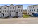 Three-story townhouses with white siding, two-car garages, and landscaping at 77 Werner Brook Way, Atlanta, GA 30354