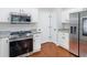 Stainless steel range and microwave in kitchen with white cabinets at 144 Wyckliffe Dr, Locust Grove, GA 30248