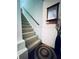 Carpeted staircase with a wooden handrail and decorative rug at 2606 Ramblewood Ct, Acworth, GA 30102