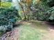 Landscaped backyard with mature trees and a bird feeder at 2606 Ramblewood Ct, Acworth, GA 30102