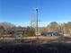 Wind turbine on a property with a pond and home, promoting sustainability at 6225 Collins Nw Rd, Acworth, GA 30101