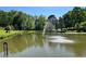 Picturesque pond featuring a water fountain, enhancing the property's curb appeal at 6225 Collins Nw Rd, Acworth, GA 30101
