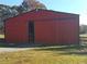 Red metal barn with large sliding doors and a spacious footprint at 6225 Collins Nw Rd, Acworth, GA 30101