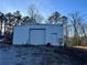 White metal outbuilding with a roll-up door and a side entrance at 6225 Collins Nw Rd, Acworth, GA 30101