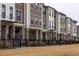 Row of townhouses with brick and wood siding, and black fencing at 362 Olmstead Way # 23, Alpharetta, GA 30002