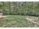 Large, grassy backyard surrounded by trees at 5833 Wind Haven Nw Ct, Kennesaw, GA 30152