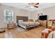 Spacious bedroom with hardwood floors, a ceiling fan, and ample closet space at 5833 Wind Haven Nw Ct, Kennesaw, GA 30152