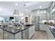 Spacious kitchen with light green cabinets, large island, and stainless steel appliances at 5215 Maggie Mae Ln, Cumming, GA 30028