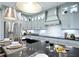 Modern kitchen with light green cabinets, a large island, and a stainless steel range hood at 5215 Maggie Mae Ln, Cumming, GA 30028