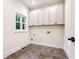 Bright laundry room with white cabinets and dark gray floor tiles at 1617 Lenox Rd, Atlanta, GA 30306