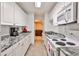 Galley kitchen with granite countertops and white cabinets at 738 Key Largo Ct, Auburn, GA 30011