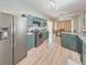 Kitchen with green cabinets, stainless steel appliances, and light wood floors at 388 Oakhaven Way, Villa Rica, GA 30180