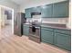 Modern kitchen with stainless steel appliances and teal cabinets at 388 Oakhaven Way, Villa Rica, GA 30180