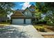 Two-story house with stone and wood exterior, three-car garage, and landscaping at 2413 Mcintosh Dr, Locust Grove, GA 30248