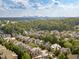 Aerial perspective of a neighborhood with various houses and lush greenery, featuring a city skyline at 1829 Buckhead Valley Ne Ln, Atlanta, GA 30324