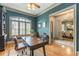 Home office with built-in bookshelves, hardwood floors, and view of dining room at 1829 Buckhead Valley Ne Ln, Atlanta, GA 30324