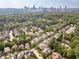 Aerial view showcasing a neighborhood's beautiful homes and landscaping with a distant city view at 1829 Buckhead Valley Ne Ln, Atlanta, GA 30324