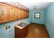 Laundry room with wood cabinets and a utility sink at 2994 Ravenwolfe Way, Snellville, GA 30039