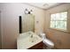 Small bathroom with a single vanity, toilet and window at 2994 Ravenwolfe Way, Snellville, GA 30039