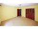 Well-lit bedroom with wood closet doors and access to a hallway at 2994 Ravenwolfe Way, Snellville, GA 30039
