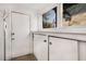 Laundry room with white cabinets, a window, and an exterior door at 56 17Th Ne St, Atlanta, GA 30309