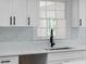 Modern kitchen features white cabinets, quartz countertops, and a black faucet at 772 Brookwood Sw Ter, Lilburn, GA 30047