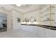 Bright bathroom with double vanity, black marble countertop, and glass shelving at 850 Camden Park Ct, Atlanta, GA 30342