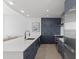 Modern kitchen with white quartz island and dark blue cabinetry at 3325 Piedmont Rd # 2203, Atlanta, GA 30305