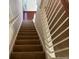 Staircase with carpeted steps and wooden handrail at 635 Beddick Ln, Atlanta, GA 30349