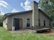 Back of house with wood siding, a deck, and partially boarded windows at 3593 Riverchase Dr, Decatur, GA 30034