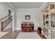 Sitting room with hardwood floors, piano, and decorative cabinet at 1988 Skybrooke Ct, Hoschton, GA 30548