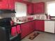 Bright kitchen featuring red cabinets, black appliances, and ample counter space at 1441 Lockwood Dr, Atlanta, GA 30311