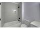 Clean bathroom, grey tile shower, white bathtub and toilet at 4847 Basingstoke Dr, Suwanee, GA 30024