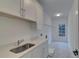 Bright laundry room with a sink, cabinets, and patterned flooring at 4847 Basingstoke Dr, Suwanee, GA 30024