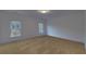 Spacious bedroom with neutral carpeting and two large windows at 4847 Basingstoke Dr, Suwanee, GA 30024