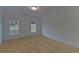 Spacious bedroom with neutral carpeting and two large windows at 4847 Basingstoke Dr, Suwanee, GA 30024