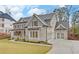 Two story house with gray brick, metal roof, and landscaping at 4847 Basingstoke Dr, Suwanee, GA 30024