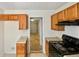 Kitchen with oak cabinets, black stove and view into garage at 3853 Cress Way Dr, Decatur, GA 30034