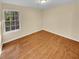Simple bedroom with hardwood floors and large window at 309 Quail Run, Roswell, GA 30076