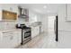 Modern kitchen with white cabinets, stainless steel appliances, and gray backsplash at 1760 Waterton Ln, Lithonia, GA 30058