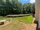 Landscaped backyard with privacy hedge and grassy area at 617 Vinings Estates Se Dr, Mableton, GA 30126