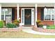 Brick house with a front porch, landscaping, and a black front door at 3824 Smith Creek Ct, Buford, GA 30519